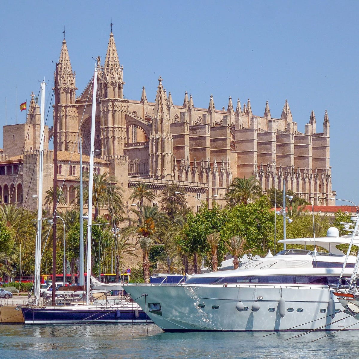 A catedral de Palma vista da água, com os arcos da muralha e o parque em primeiro plano
