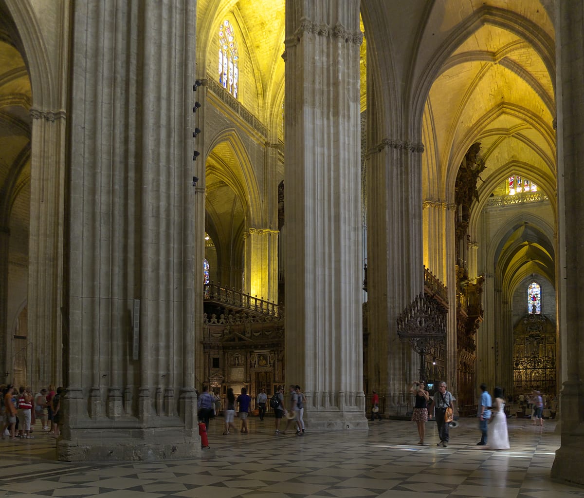 Interior da catedral de Sevilha, com colunas e abóbadas góticas
