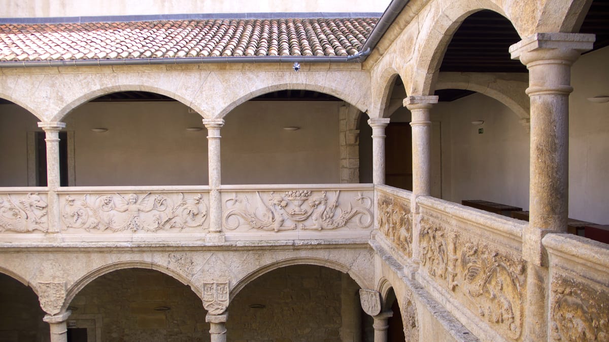 Pátio de dois andares com arcos e balaustrada esculpida, no Palacio de los Águila