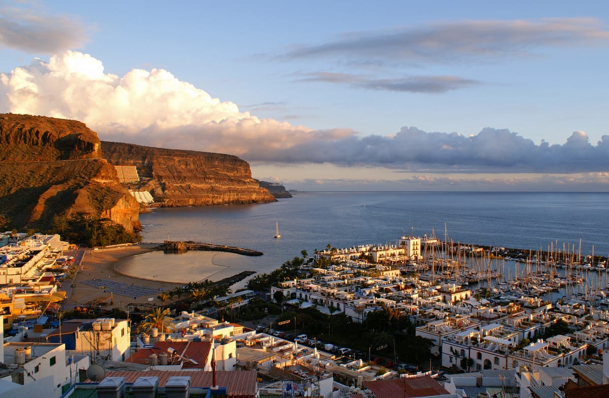 Porto de Mogán ao entardecer, com casas brancas junto à água